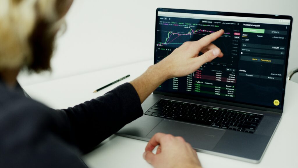 Digital Marketing Myths vs Facts – person analyzing trading charts and performance data on a laptop to separate real trends from misleading insights.